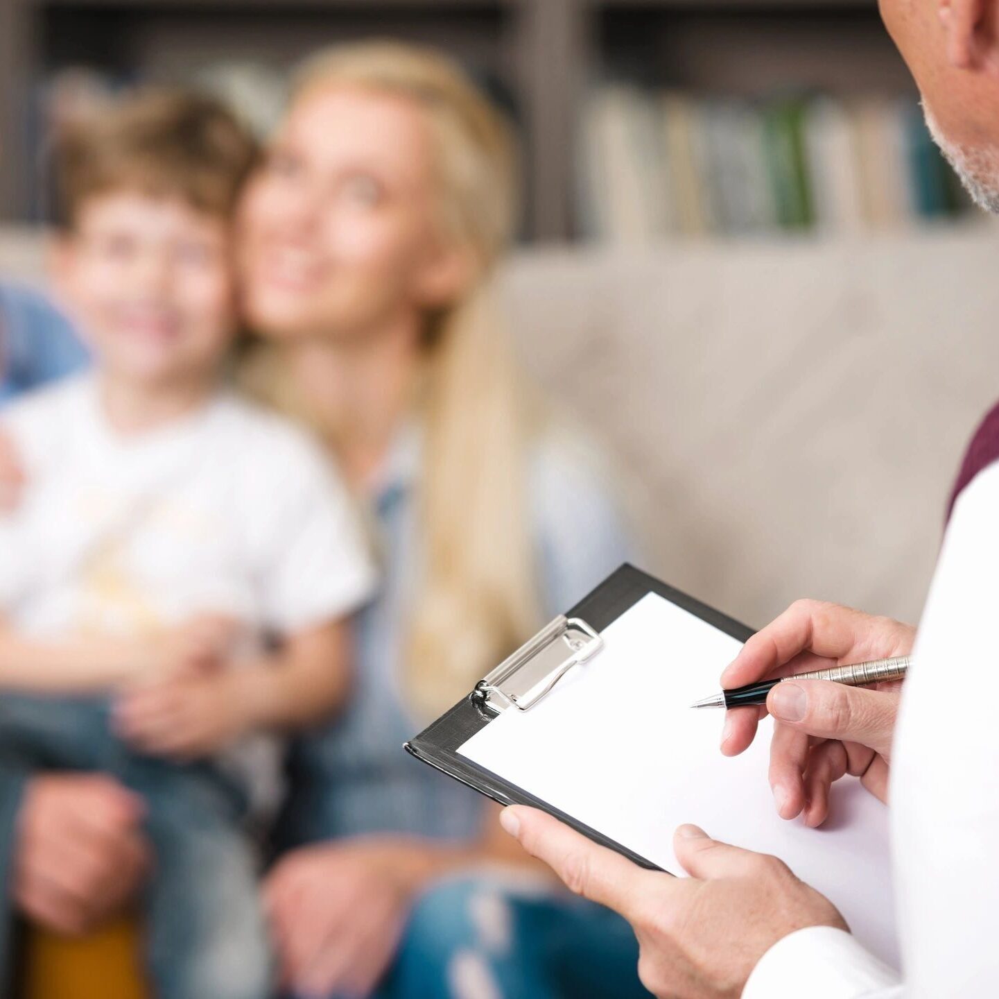 Lighthouse family therapy - family therapy service with a smiling caucasian mother and son with a therapist taking notes